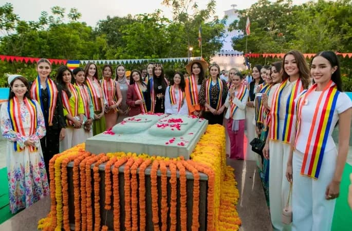 Group in sashes standing behind a long table decorated with marigold garlands