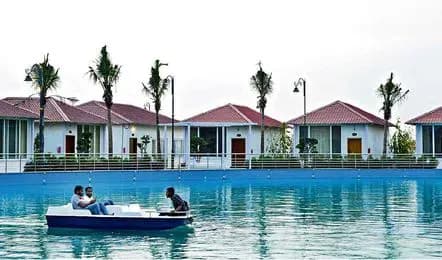 Pedal boat on a pool before a row of white cottages