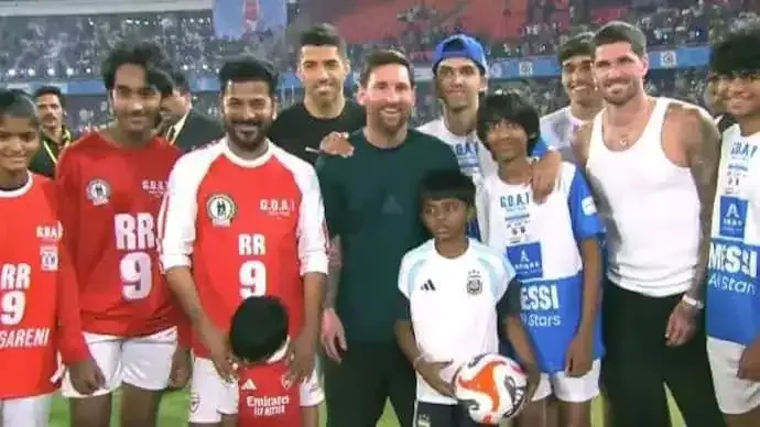 Footballers and children posed together on a pitch