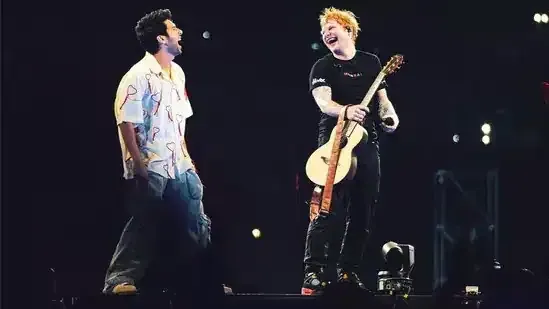 Two musicians performing on a darkened stage