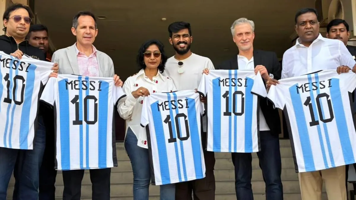 People holding up football shirts at a presentation