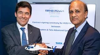 Two men shaking hands holding a model helicopter