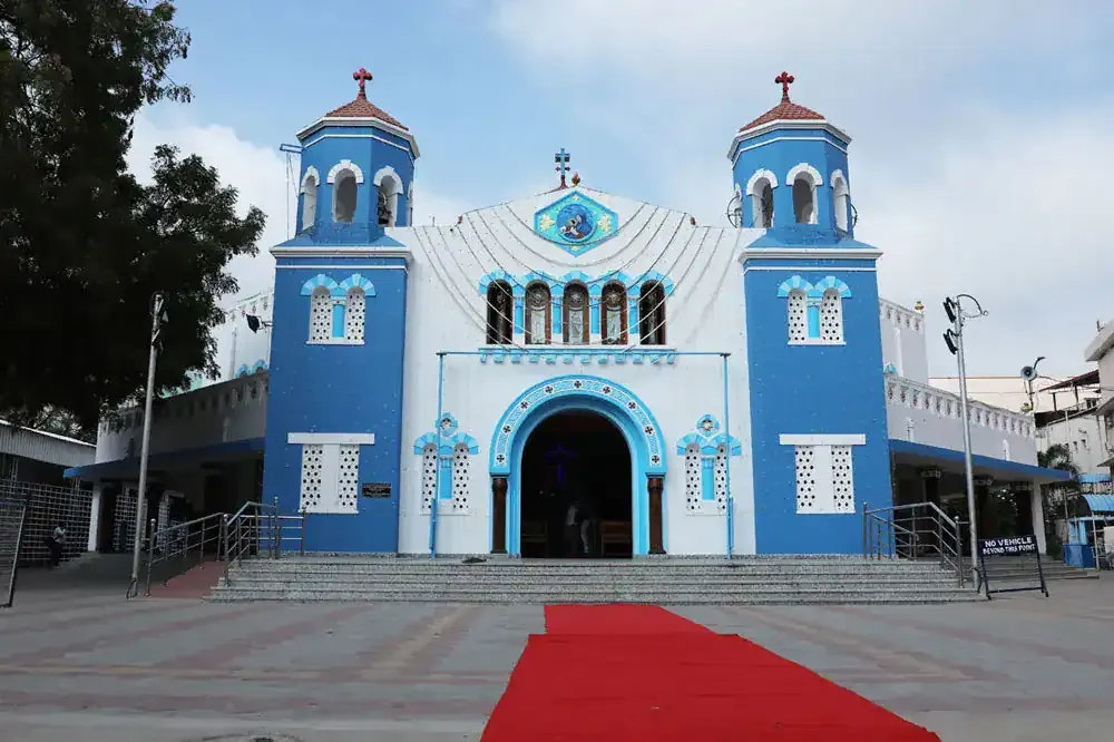 Blue and white church with a red carpet at the entrance
